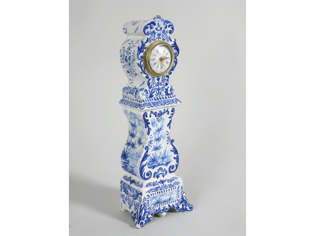 Appraisal: A Delft Mantel Clock with circular dial decorated landscape scrolls