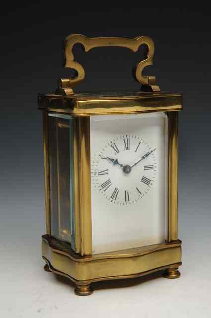 Appraisal: A CONTINENTAL CARRIAGE TIMEPIECE with serpentine case and scrolling handle