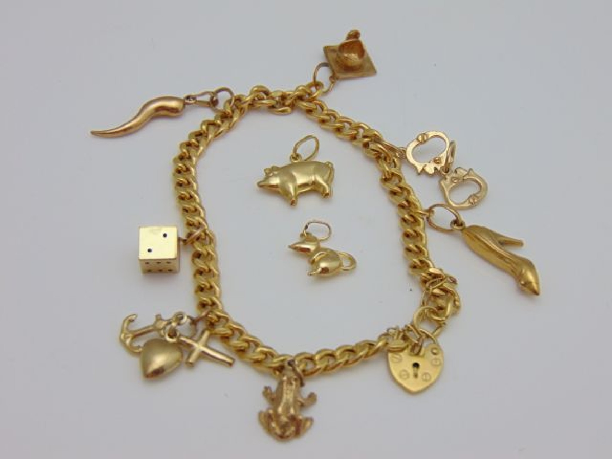 Appraisal: A ct gold charm bracelet hung with seven gold charms