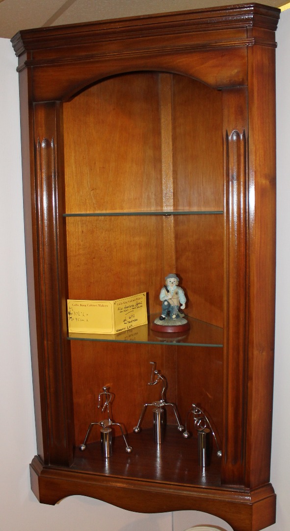 Appraisal: A yew finish hanging corner cabinet with a fixed moulded