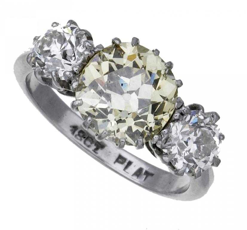 Appraisal: A DIAMOND THREE-STONE RING the larger cushion shaped fancy yellow