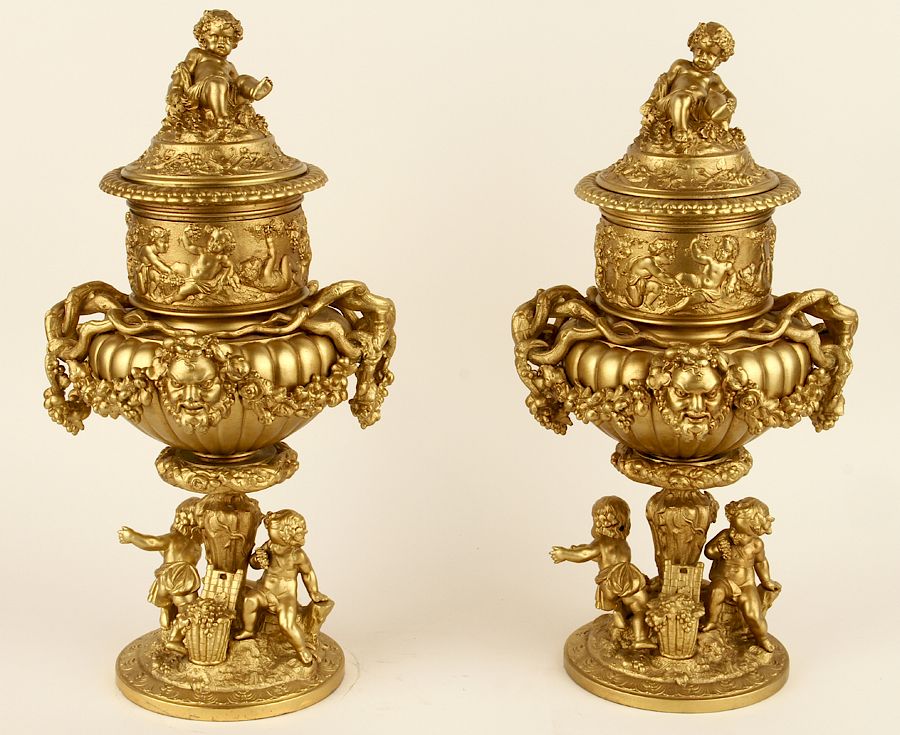 Appraisal: PAIR BRONZE BAROQUE STYLE URNS WITH PUTTO FIGURES A pair