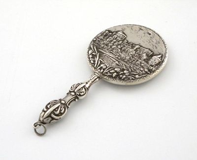 Appraisal: A modern miniature hand mirror circular with an embossed scene