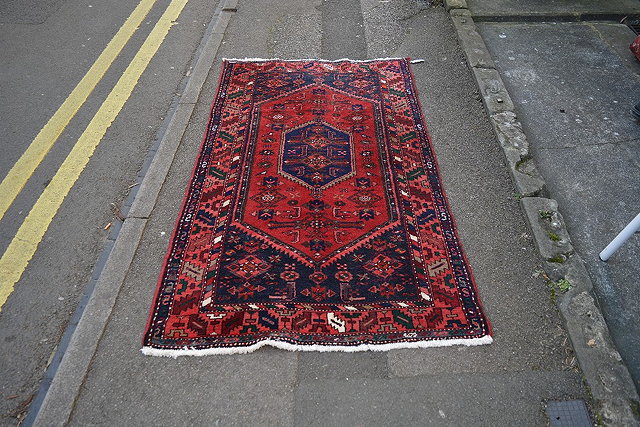 Appraisal: A Iranian red ground rugwith blue central shape medallion and