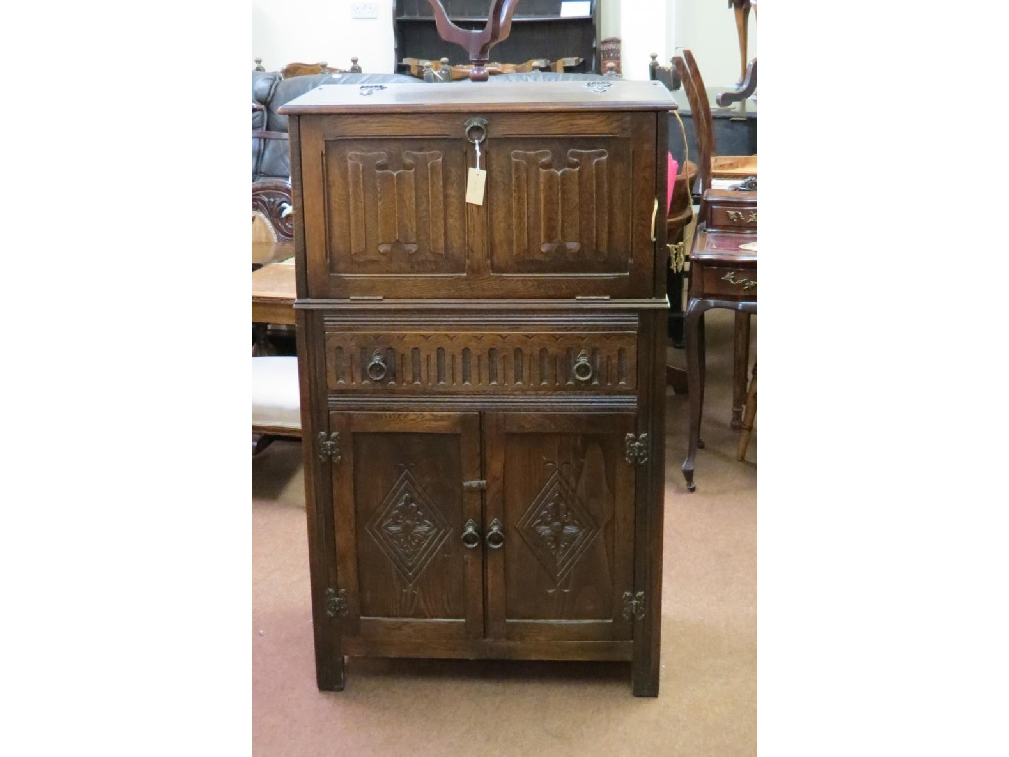 Appraisal: A Jaycee dark oak cocktail cabinet linenfold fall front above