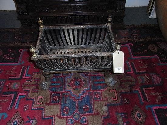 Appraisal: A SQUARE CAST IRON FIRE BASKET with brass finials and