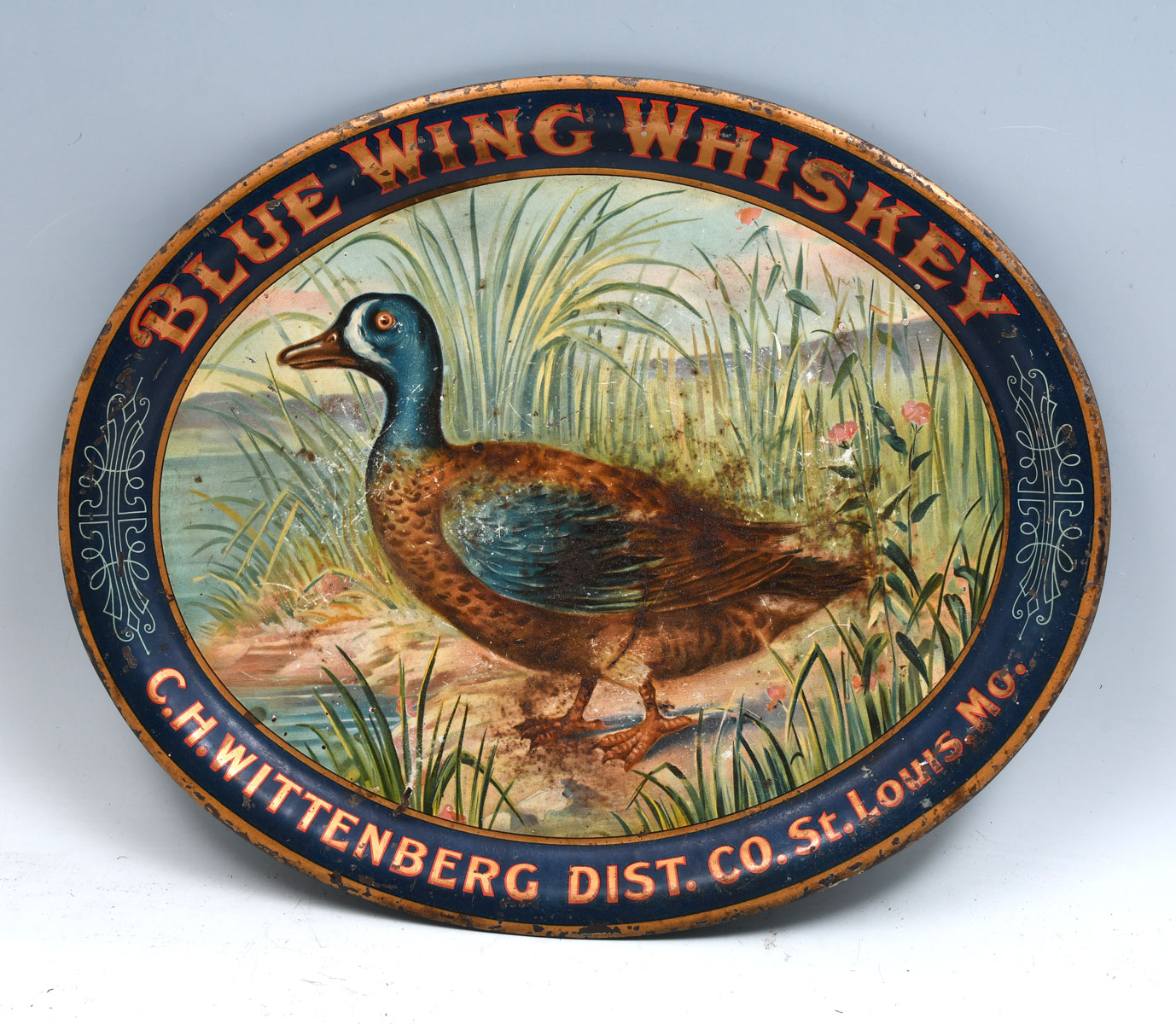 Appraisal: BLUE WING WHISKEY TIN ADVERTISING TRAY Outstanding graphics of a