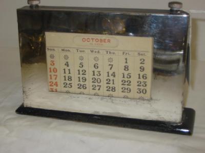 Appraisal: AN EBONISED PERPETUAL DESK CALENDAR of oblong form with printed