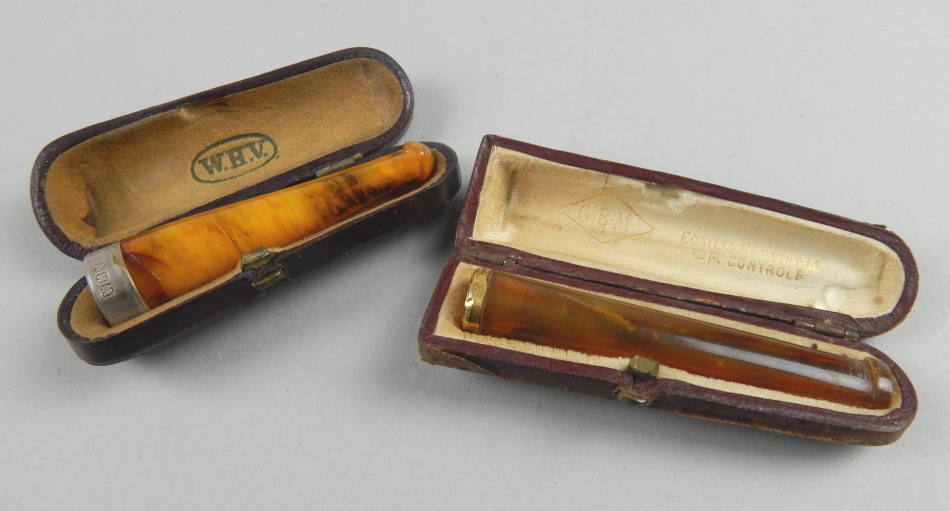 Appraisal: Two cheroot holders each in amber one with yellow metal