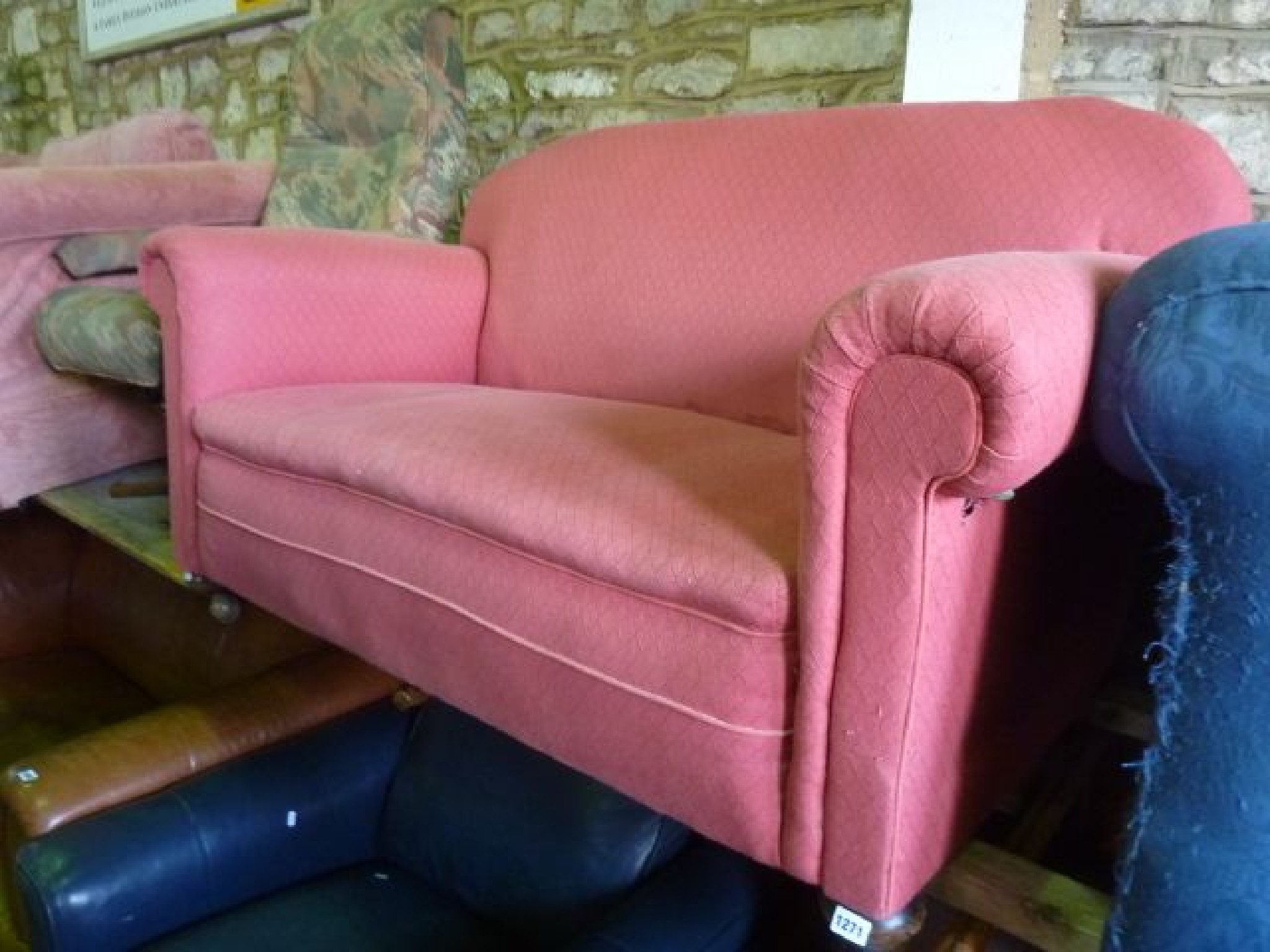 Appraisal: A small Edwardian two seat cottage sofa with scrolled arms