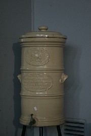 Appraisal: An antique water cooler with metal stand