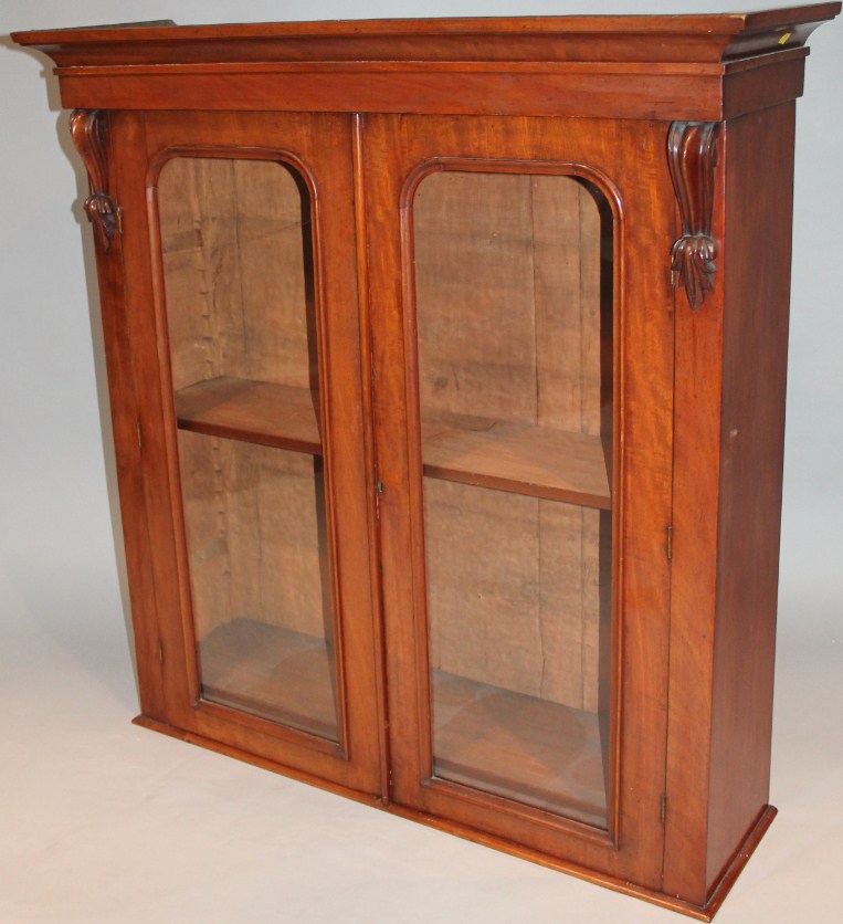 Appraisal: A thc mahogany bookcase top the overhanging cornice raised above