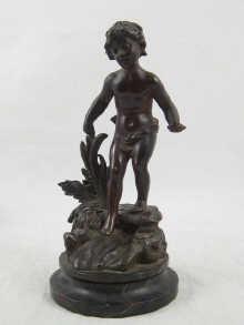 Appraisal: A bronze figure of a child on rocks on marble