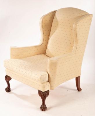 Appraisal: An upholstered wing back chair with ball and claw feet