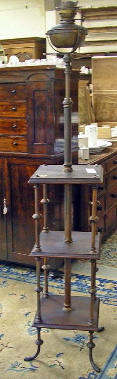 Appraisal: A Victorian mahogany and brass oil standard lamp fitted shelves