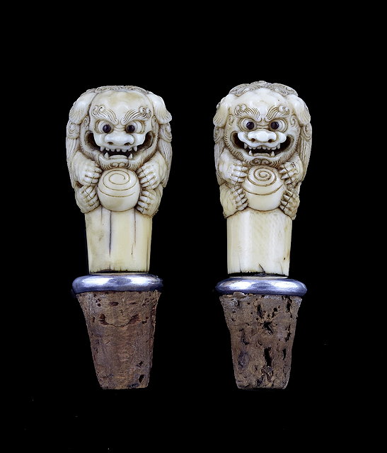 Appraisal: A pair of cane handles th Centurycarved as shishi holding