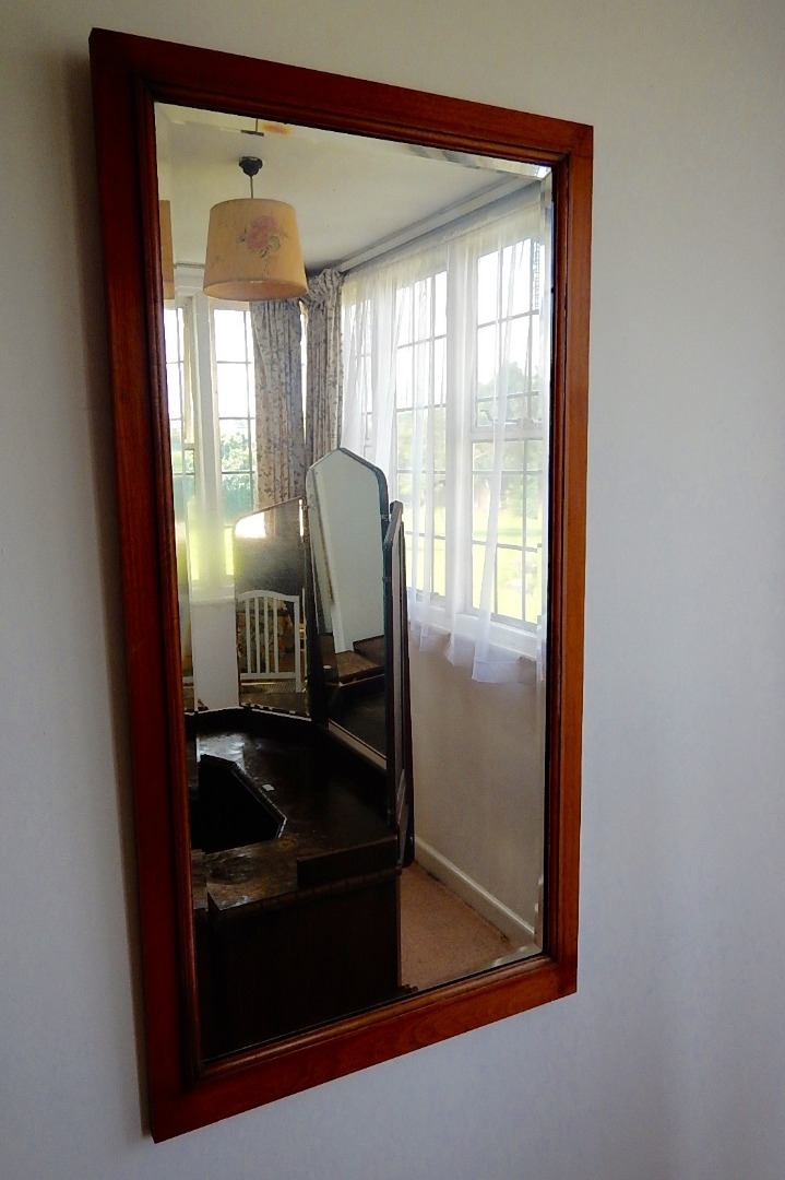 Appraisal: A bevelled rectangular mirror in plain walnut frame with moulded