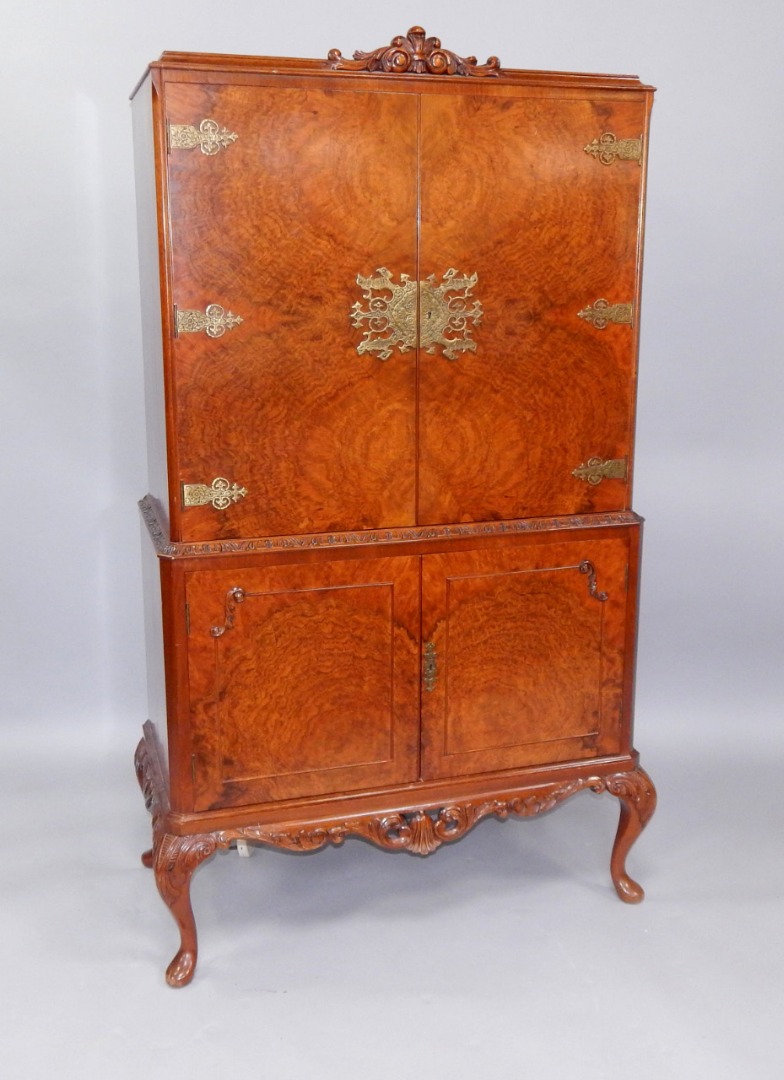 Appraisal: A s walnut cocktail cabinet the top with brass strap