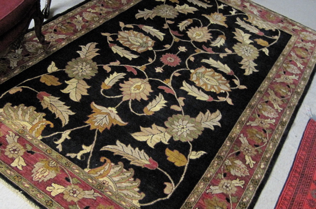 Appraisal: AFGHANI PERSIAN CARPET overall scrolling floral raceme decoration on black