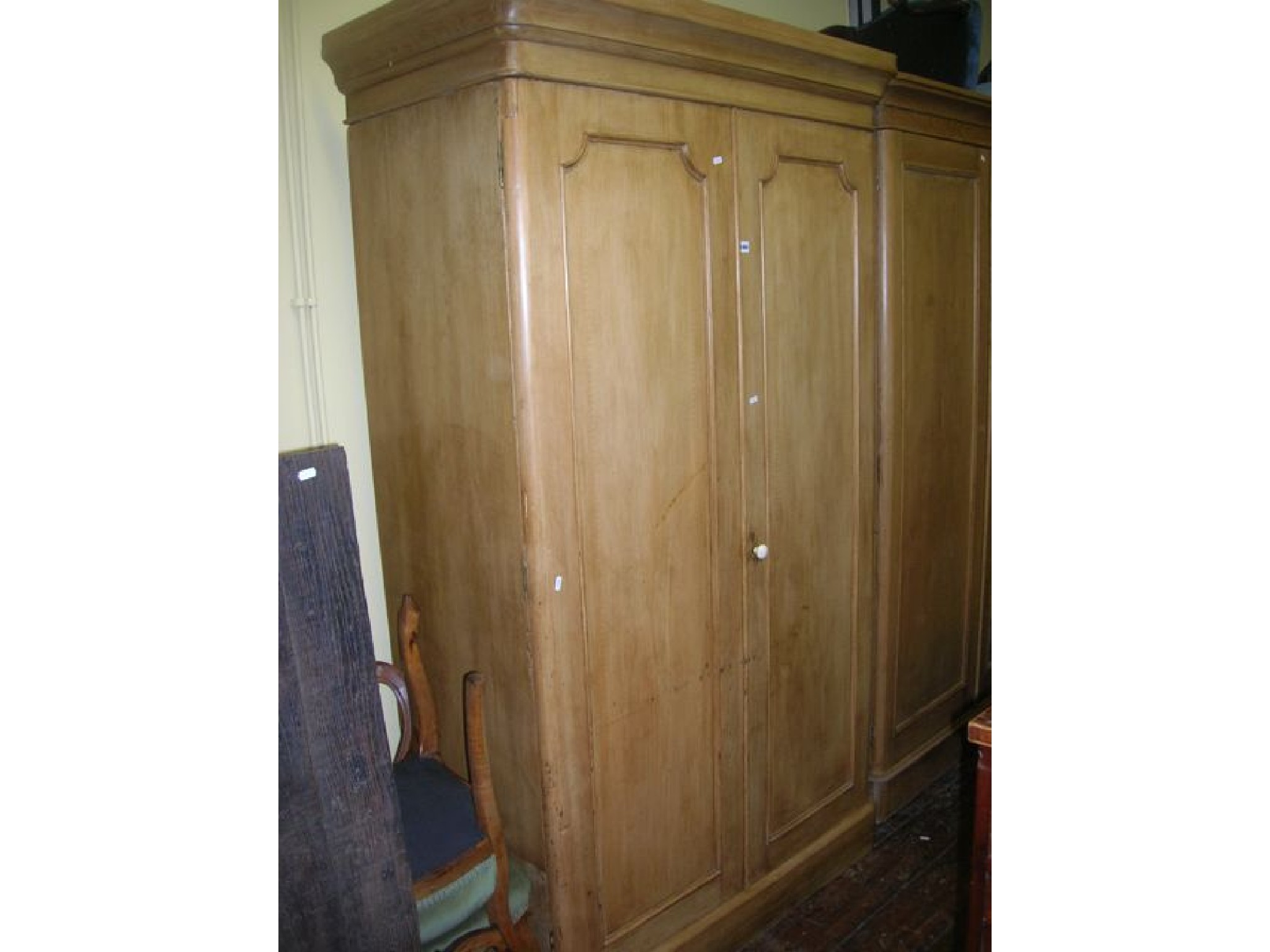 Appraisal: A Victorian stripped and waxed pine wardrobe enclosed by two