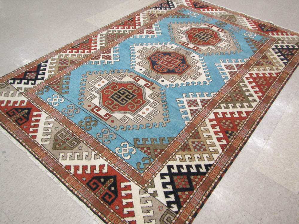 Appraisal: HAND KNOTTED ORIENTAL CARPET Indo-Kazak three geometric medallion design on