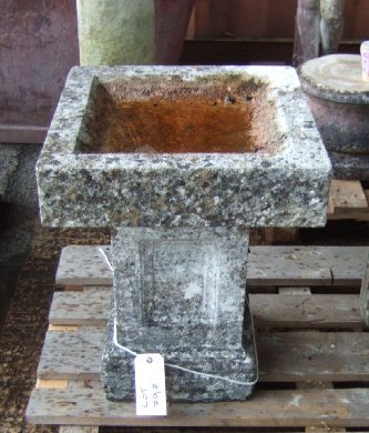 Appraisal: A stone square topped bird bath raised on a reconstituted