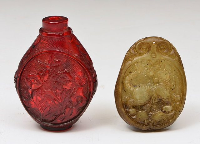 Appraisal: A CHINESE RED AMBEROID SNUFF BOTTLE of flattened oviform decorated