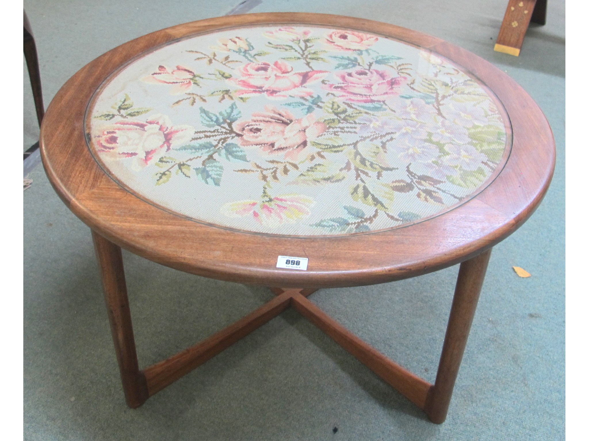 Appraisal: A retro circular mahogany glass topped table with floral tapestry