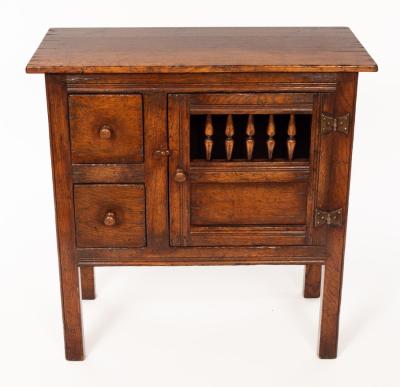 Appraisal: An oak cupboard enclosed by a spindle turned door fitted