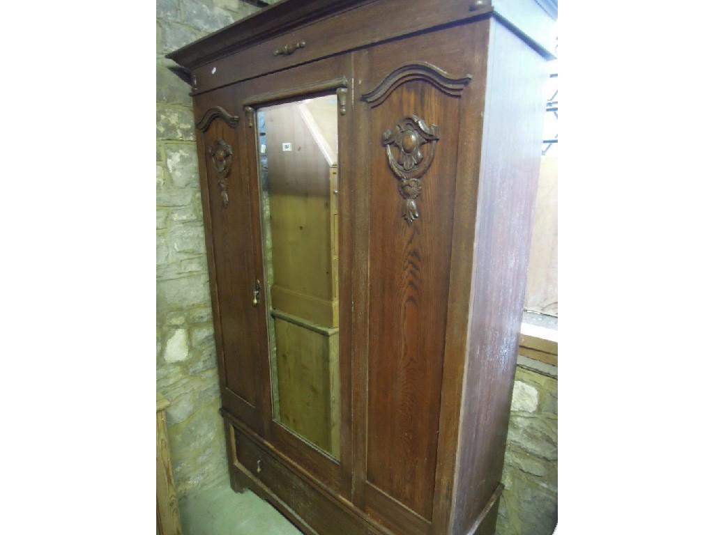 Appraisal: An Edwardian oak wardrobe enclosed by a central bevelled edged