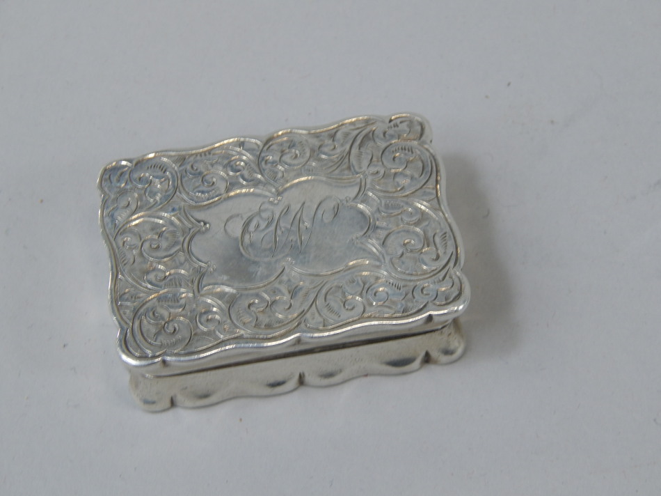 Appraisal: An Edwardian rectangular silver pill box with engraved decoration around