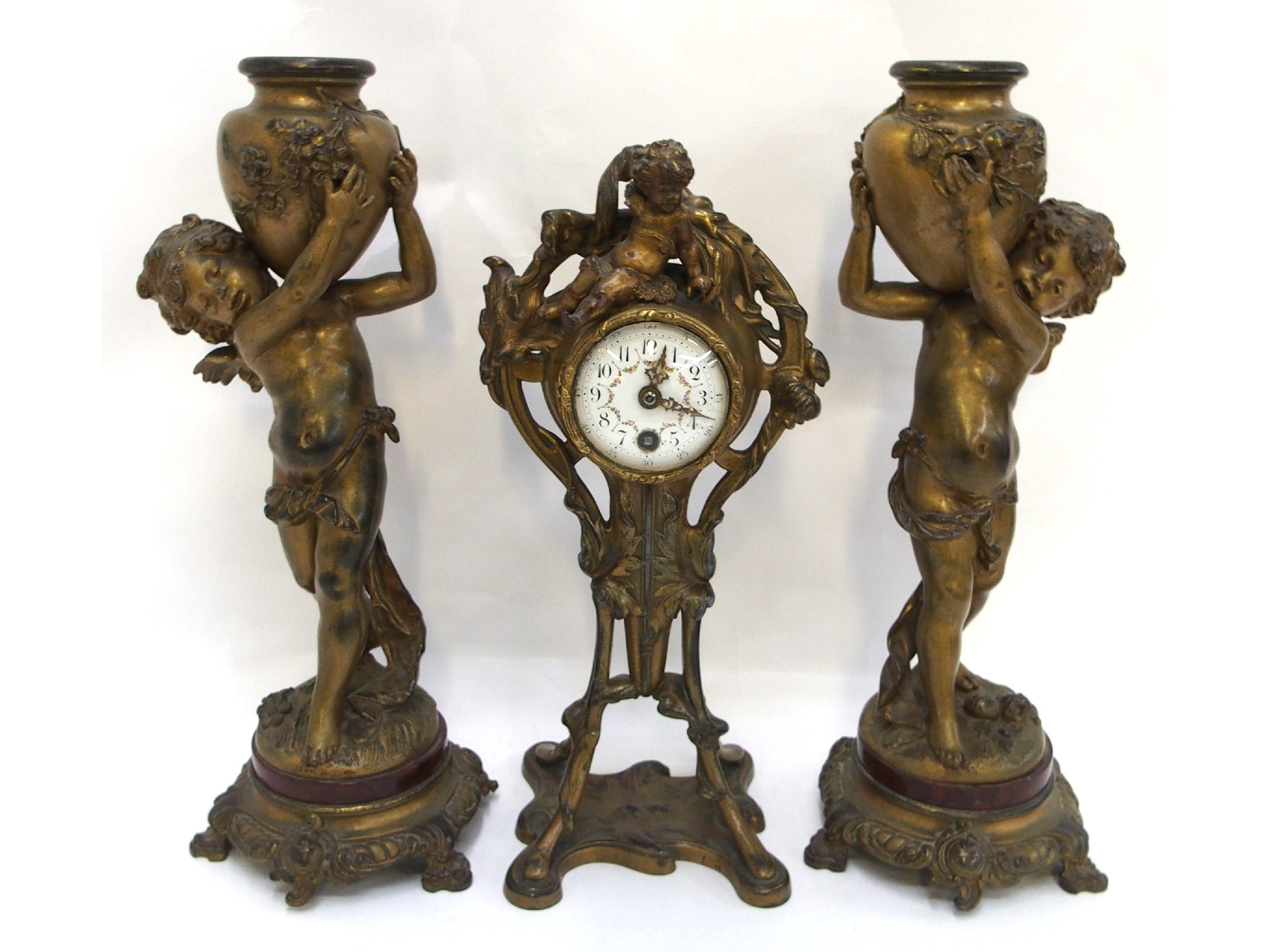 Appraisal: French gilded cherub decorated clock and garniture