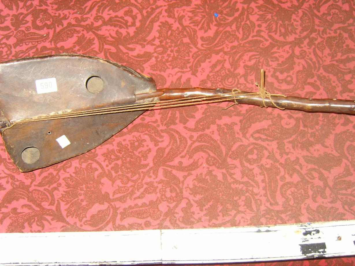 Appraisal: An ethnic stringed instrument with animal skin and stitched finish