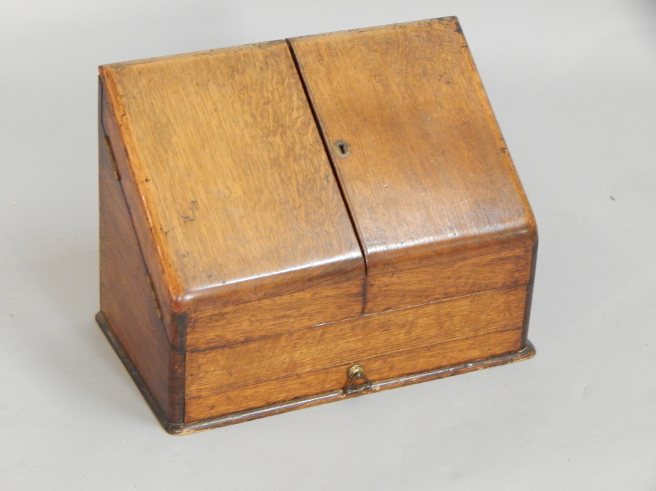 Appraisal: An Edwardian oak stationery cabinet the sloping hinged doors enclosing