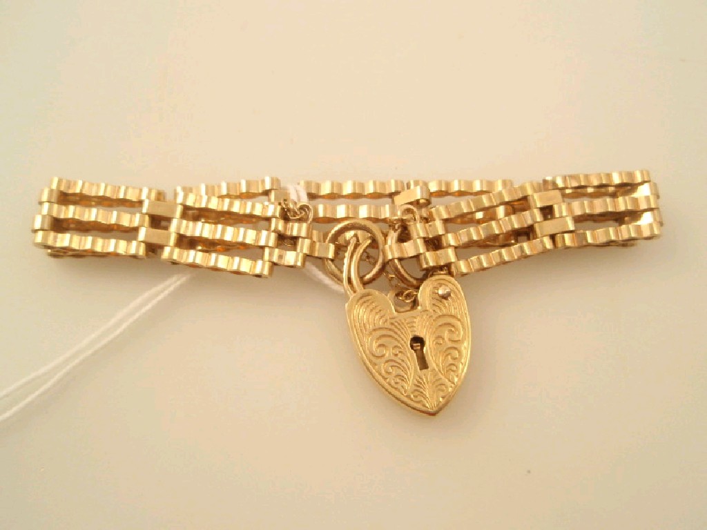 Appraisal: A ct gold corrugated three bar gate bracelet with padlock