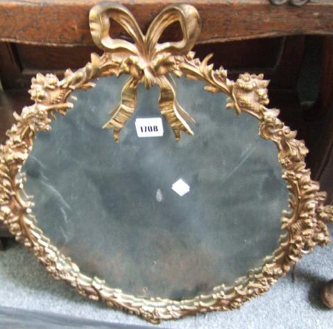 Appraisal: A gilt brass oval wall mirror with a ribbon tied