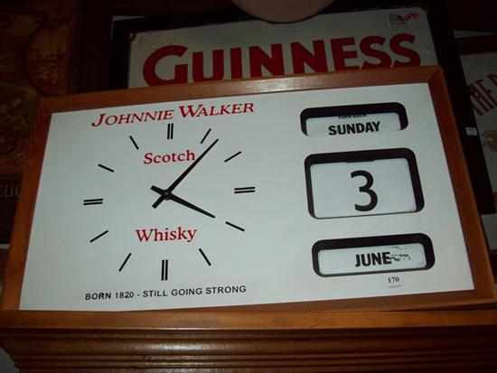 Appraisal: A JOHNNIE WALKER SCOTCH WHISKEY DAY AND DATE CLOCK