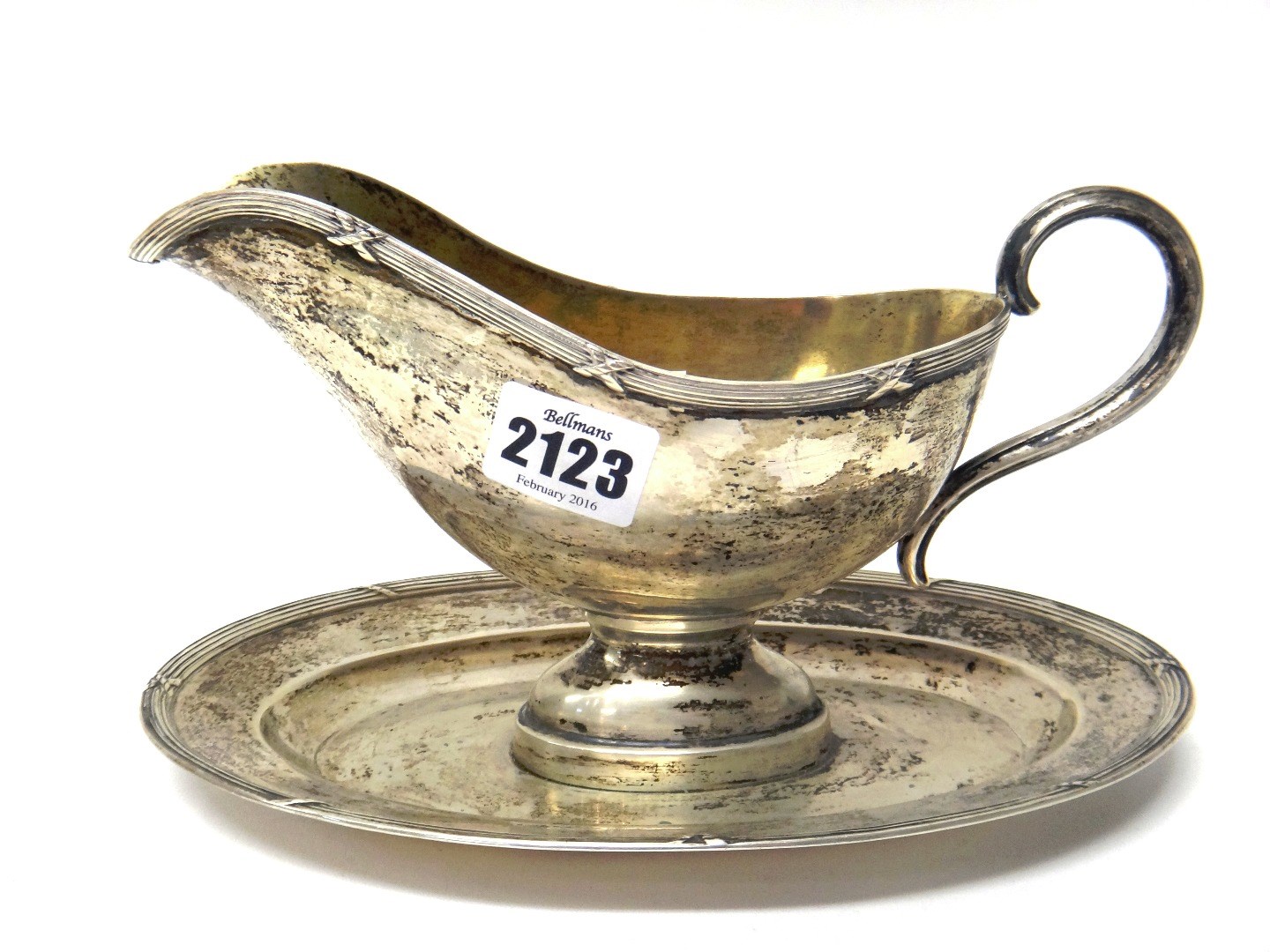 Appraisal: A German sauceboat with an integral oval stand decorated with