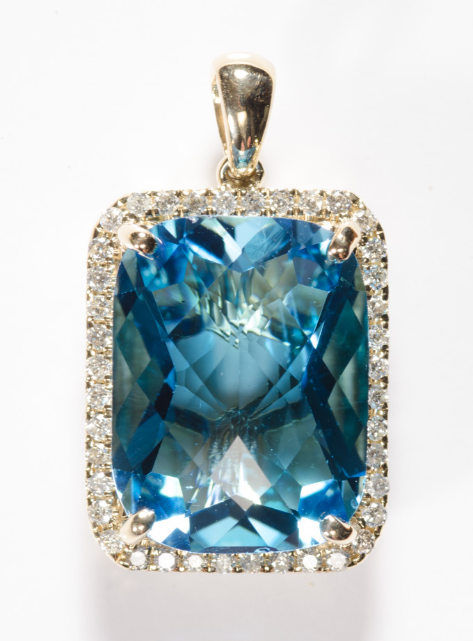 Appraisal: BLUE TOPAZ DIAMOND AND FOURTEEN KARAT GOLD PENDANT featuring a