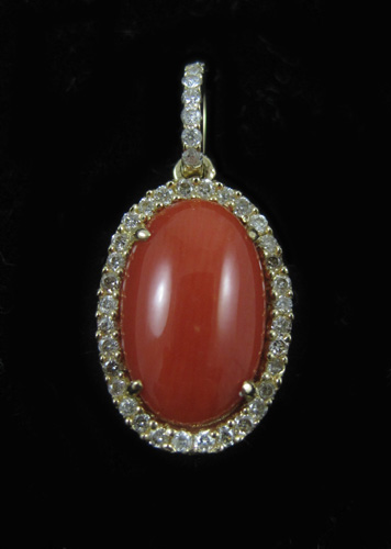 Appraisal: CORAL DIAMOND AND FOURTEEN KARAT GOLD PENDANT with round-cut diamonds