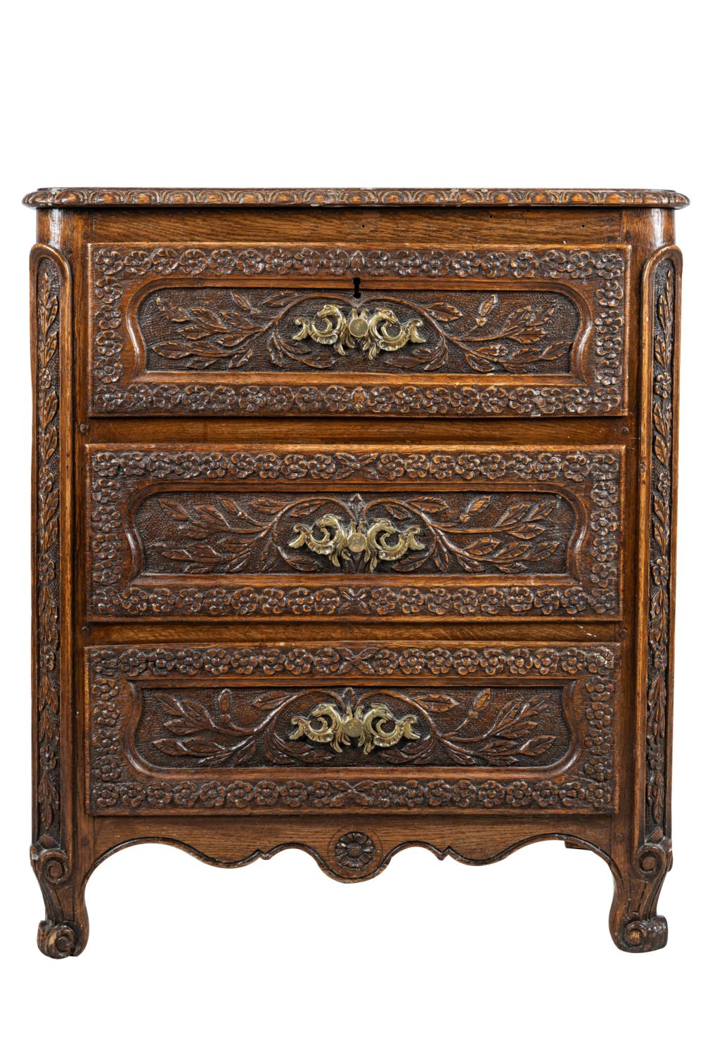 Appraisal: FRENCH CARVED OAK COMMODEwith three foliate and floral-carved paneled drawers