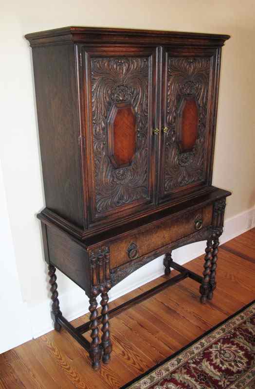 Appraisal: 'S CARVED OAK BLIND CUPBOARD Ornate carved top doors with