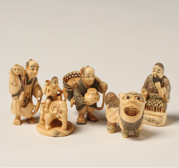 Appraisal: Japanese carved ivory netsukes peddlers figure in mythical costume and