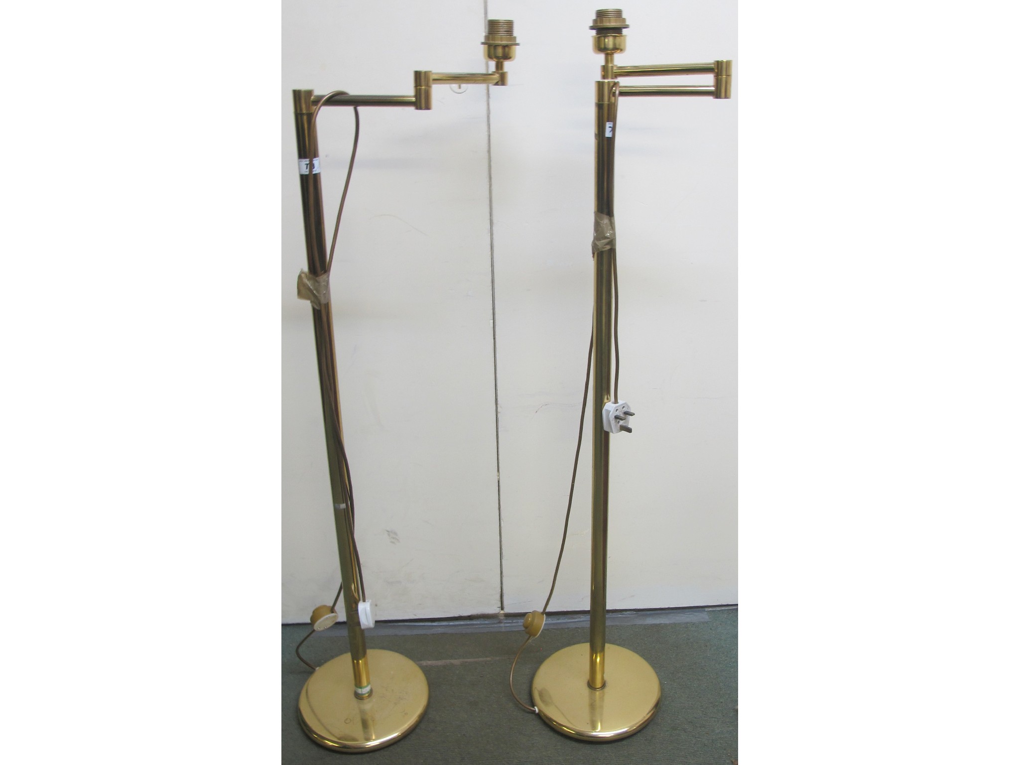 Appraisal: A pair of brass swivel standard lamps