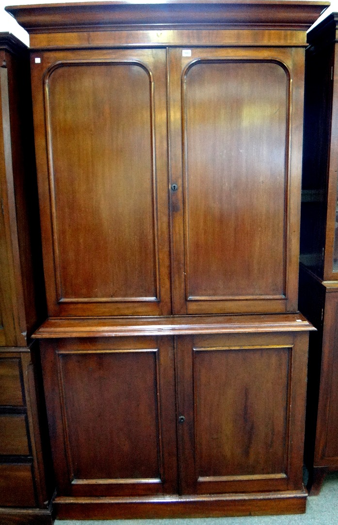 Appraisal: A George III mahogany cupboard with pair of arch panelled