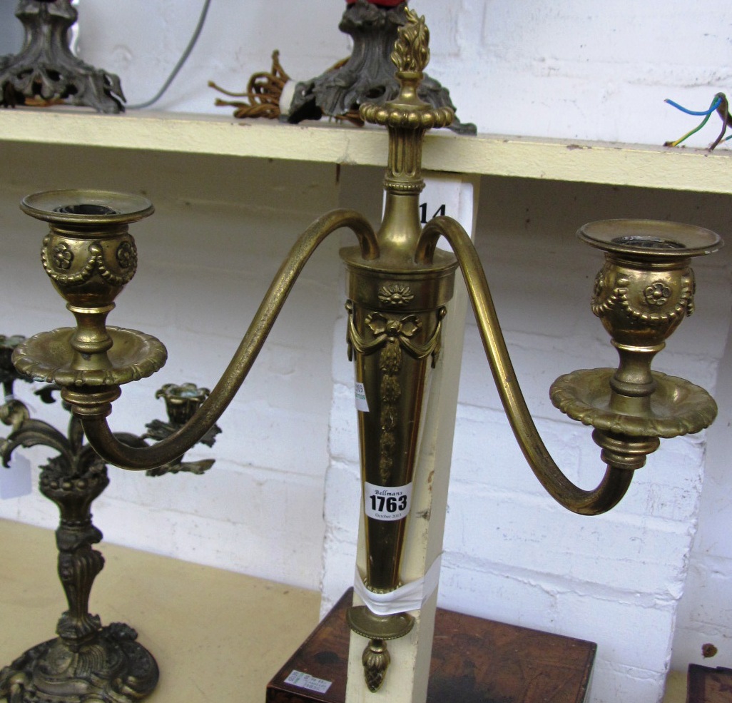 Appraisal: A pair of polished brass twin branch wall lights of