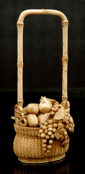 Appraisal: A JAPANESE CARVED IVORY BASKET OF FRUIT Meiji Period -