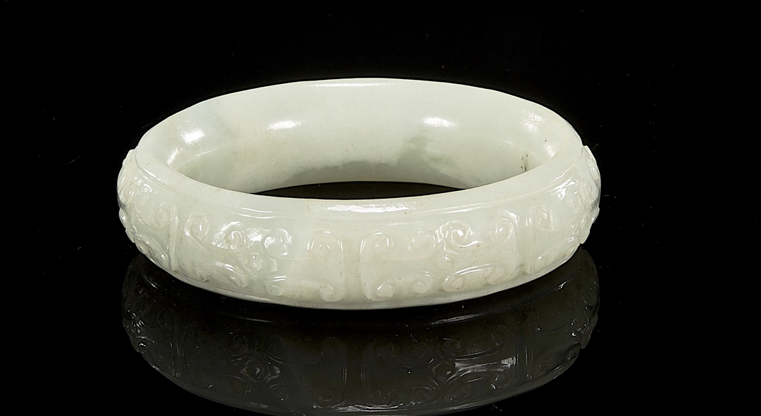 Appraisal: Chinese carved archaistic jade bangles carved in relief repeating pattern