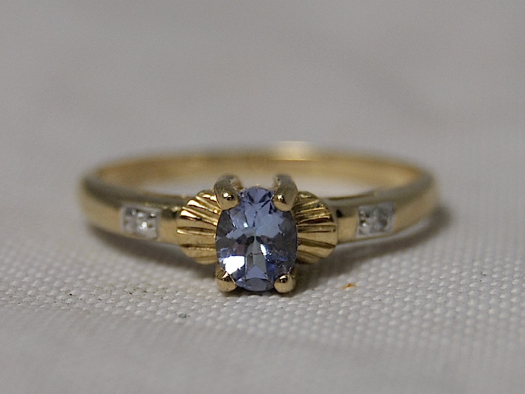 Appraisal: A ct gold ring set with tanzanite flanked by two