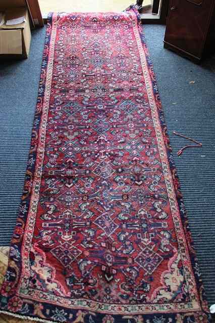 Appraisal: A RED GROUND HAMADAN RUNNER with central repeating geometric design